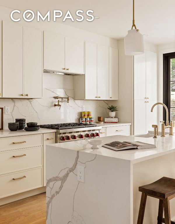 kitchen with white cabinets, light stone countertops, stove, and pendant lighting