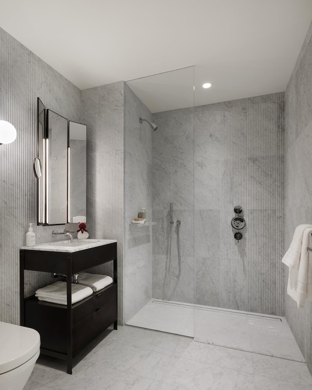 full bath with marble finish floor, a walk in shower, toilet, and vanity