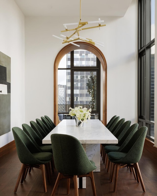 dining area with dark wood finished floors and an inviting chandelier