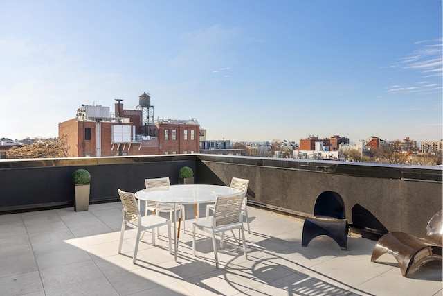 view of patio with a view of city, outdoor dining space, and a balcony