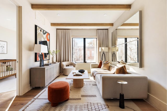 sitting room with beamed ceiling, baseboards, and wood finished floors