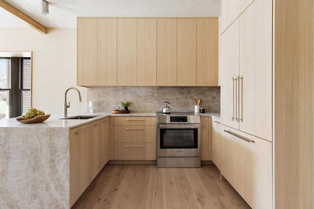 kitchen with stainless steel electric range oven, modern cabinets, a sink, and light brown cabinetry