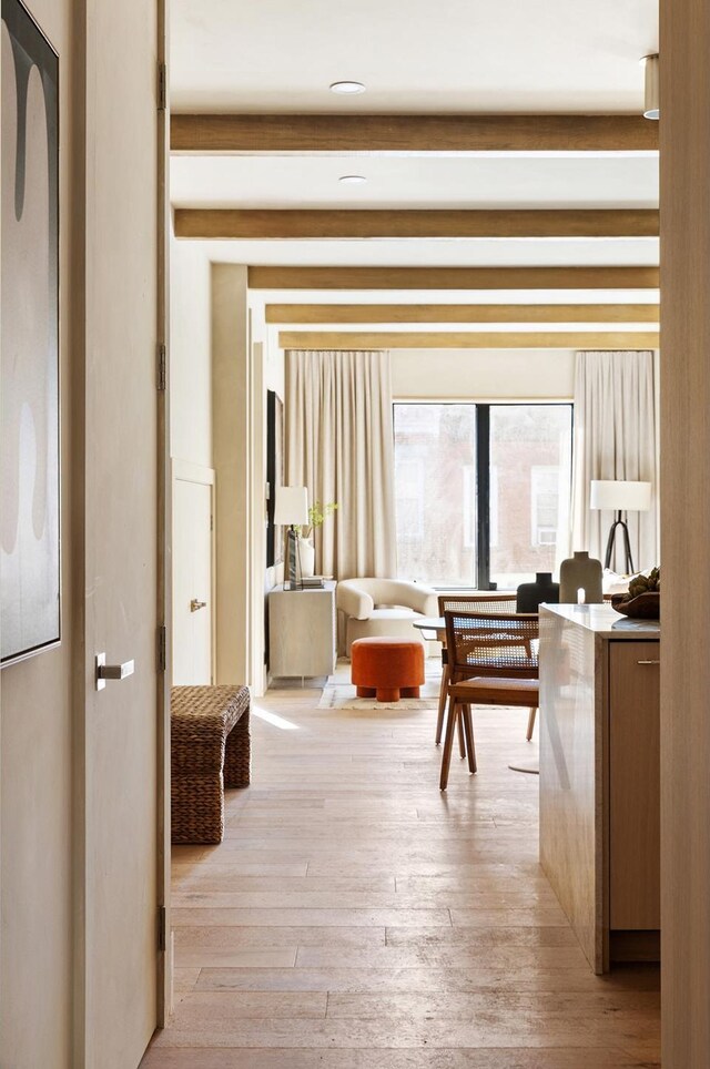 corridor featuring beam ceiling and light wood-style floors