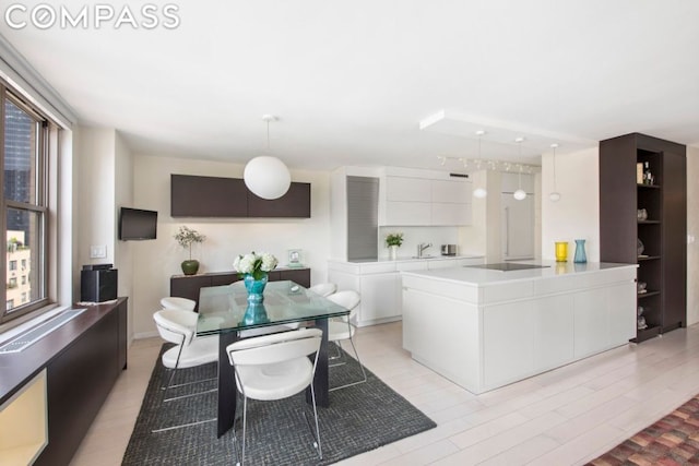 interior space featuring sink, light wood-type flooring, and a healthy amount of sunlight