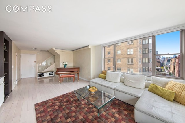 living area featuring a view of city, baseboards, and wood finished floors