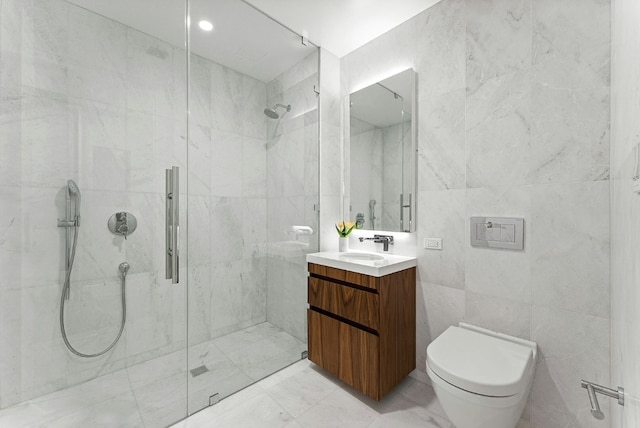 bathroom with tile walls, toilet, vanity, and tiled shower