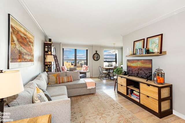 living room with a notable chandelier, crown molding, and hardwood / wood-style flooring