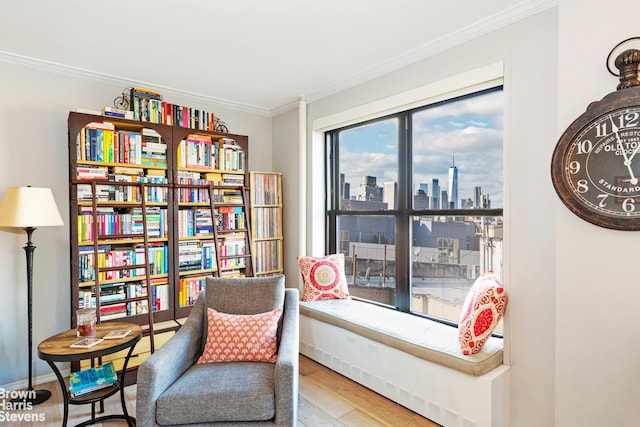 sitting room with crown molding and hardwood / wood-style floors