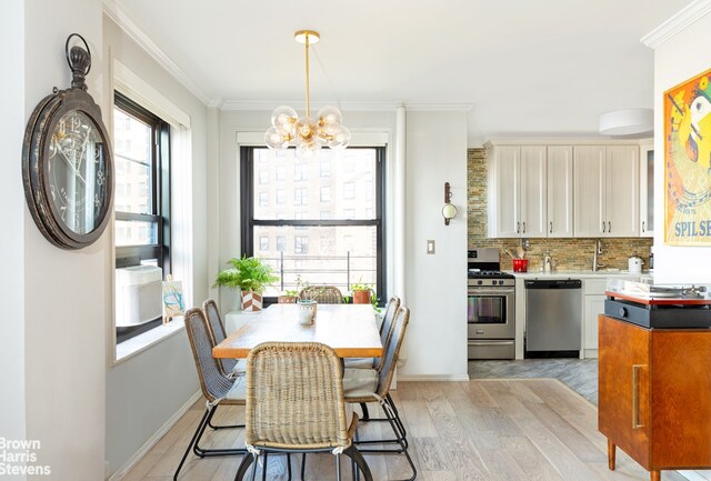 dining space with crown molding, a chandelier, and light hardwood / wood-style floors