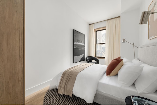 bedroom with baseboards and wood finished floors