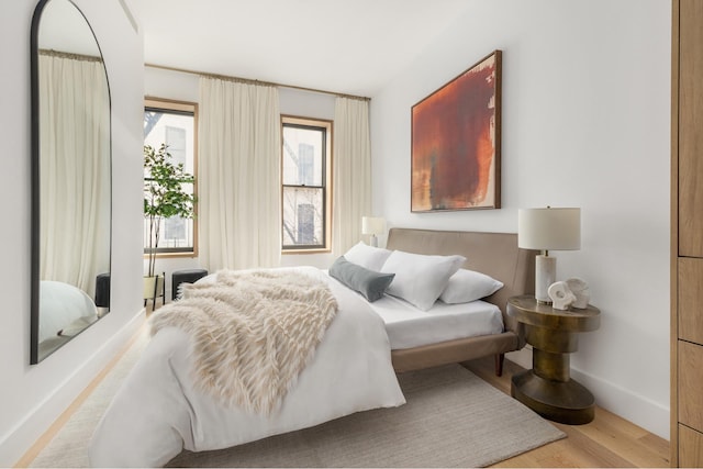 bedroom featuring baseboards and wood finished floors