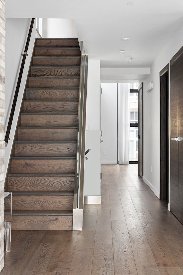 staircase featuring hardwood / wood-style flooring and baseboards