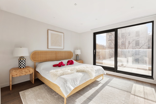 bedroom featuring access to exterior and wood finished floors