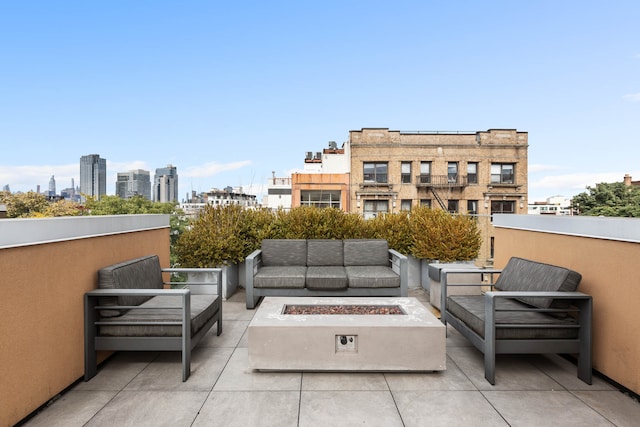 view of patio with a view of city and an outdoor living space with a fire pit