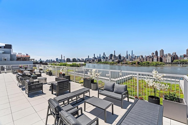 view of patio / terrace featuring a view of city, a water view, and an outdoor living space