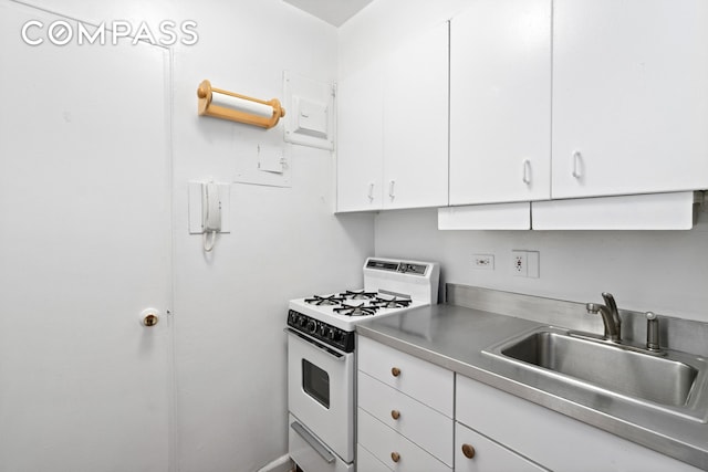 kitchen featuring stainless steel counters, white cabinetry, white gas stove, and a sink