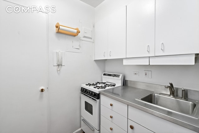 60 E 9th St Unit 235, New York City, NY 10003 - kitchen featuring gas range gas stove, a sink, white cabinets, and stainless steel countertops