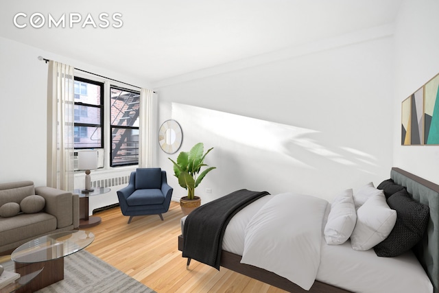 bedroom featuring radiator heating unit and wood finished floors