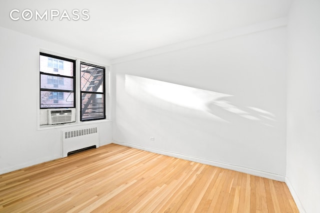 60 E 9th St Unit 235, New York City, NY 10003 - empty room featuring radiator, wood finished floors, baseboards, and cooling unit