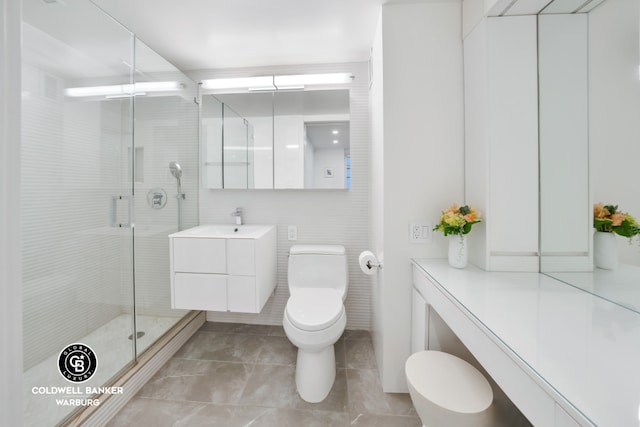 bathroom featuring tile walls, toilet, vanity, and an enclosed shower