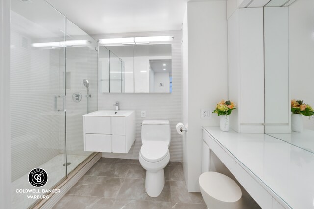 bathroom with a shower with shower door, tile walls, toilet, and vanity