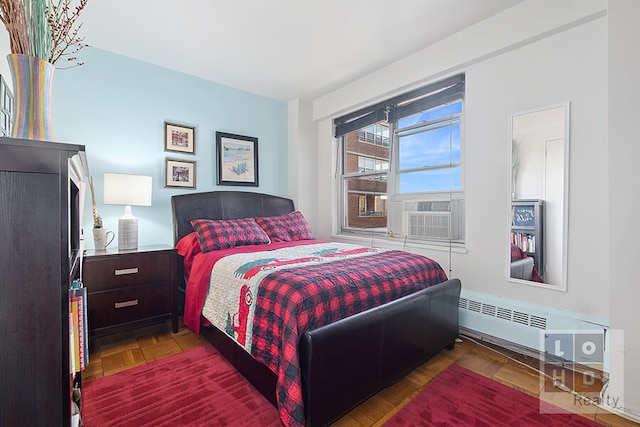 bedroom with cooling unit, parquet floors, and radiator heating unit