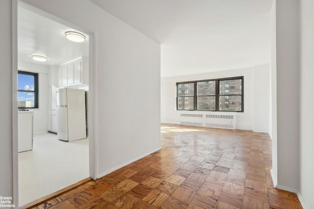 hallway featuring baseboards and radiator