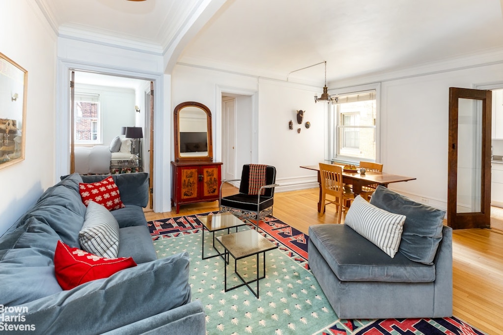 living room featuring ornamental molding, a healthy amount of sunlight, and wood finished floors