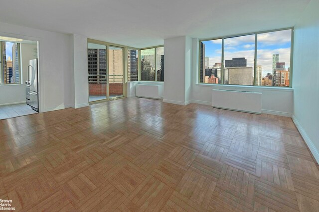 empty room featuring a healthy amount of sunlight and light parquet floors