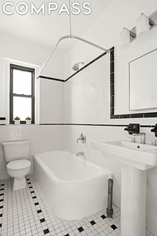 bathroom with sink, tile walls, toilet, and tile patterned flooring