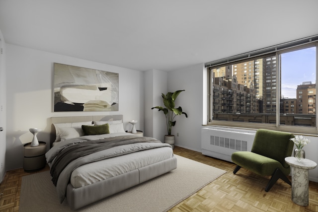 bedroom featuring radiator and light parquet flooring