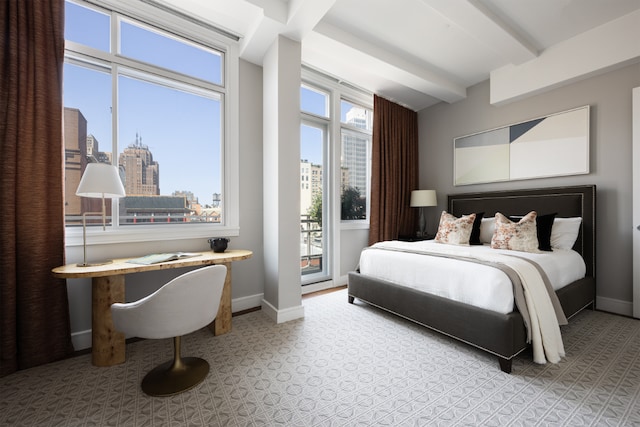 bedroom with a view of city, beam ceiling, and baseboards