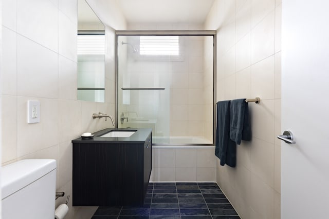 full bathroom with toilet, vanity, tile walls, tiled shower / bath, and tile patterned floors