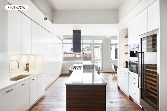 kitchen featuring light wood-style floors, wine cooler, modern cabinets, and a sink