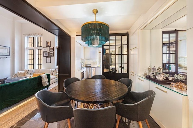 dining area with wood-type flooring, a wealth of natural light, and a chandelier