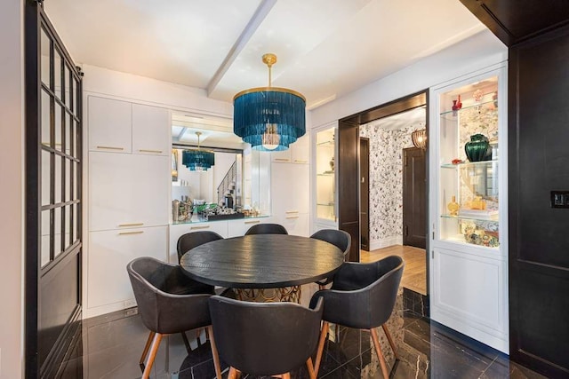 dining space featuring beamed ceiling and a chandelier