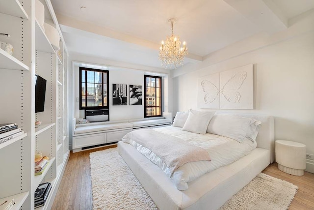 bedroom featuring beamed ceiling, wood-type flooring, and a chandelier