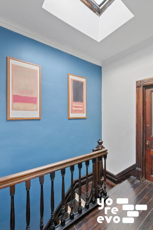 stairs featuring a skylight, baseboards, crown molding, and wood finished floors