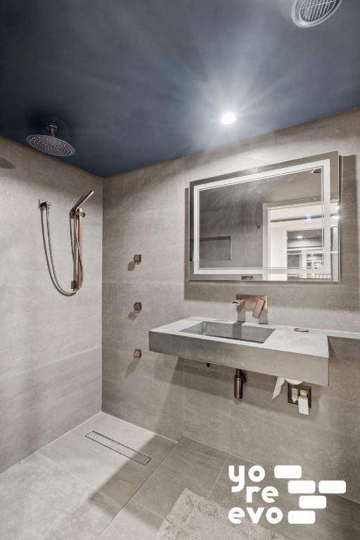 bathroom featuring visible vents, a tile shower, a sink, and tile patterned floors