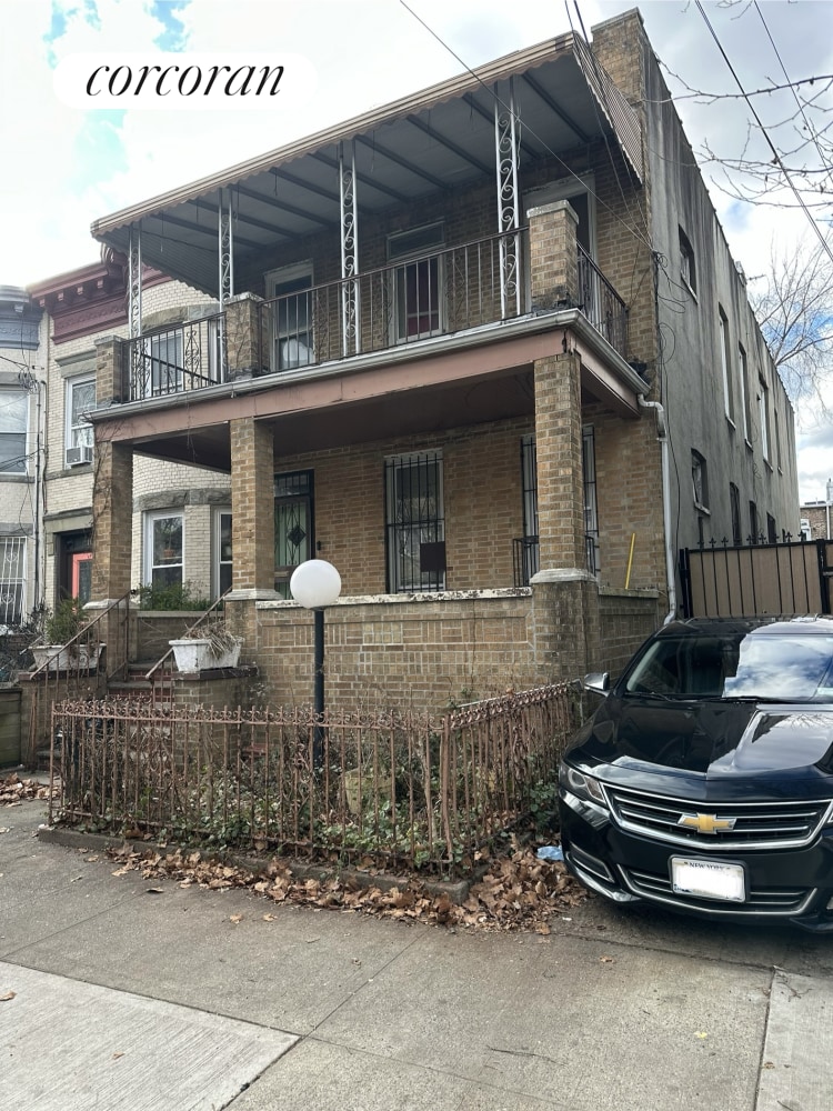 view of front facade with fence and brick siding