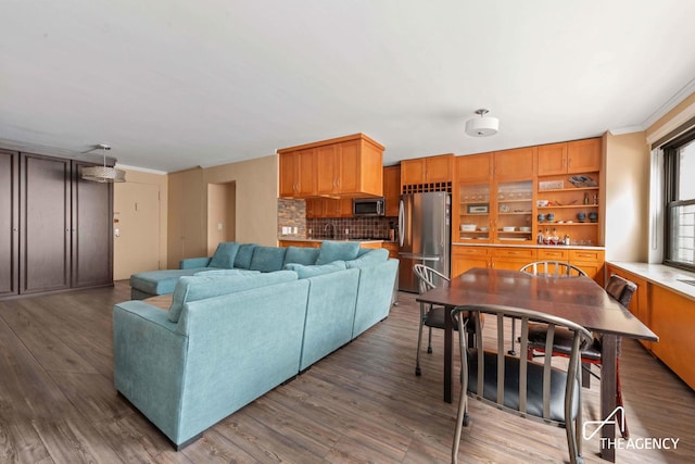 living area with ornamental molding and wood finished floors