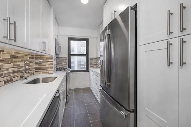 kitchen featuring a sink, decorative backsplash, light countertops, white cabinets, and appliances with stainless steel finishes