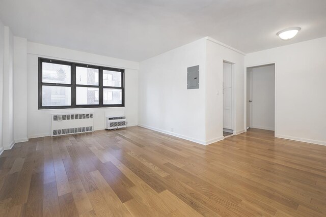 unfurnished living room with radiator heating unit and dark hardwood / wood-style flooring