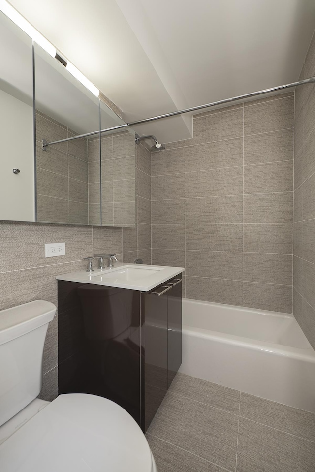 240 E 76th St Unit 7-M, New York City, NY 10021 - bathroom with vanity, shower / washtub combination, and tile walls