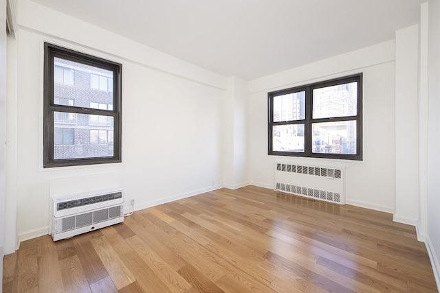240 E 76th St Unit 7-M, New York City, NY 10021 - spare room featuring radiator and light wood-type flooring