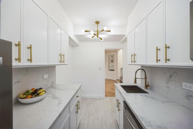 kitchen with white cabinetry, sink, backsplash, and light stone countertops