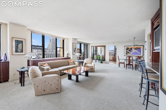 living room featuring light colored carpet, plenty of natural light, and a textured ceiling