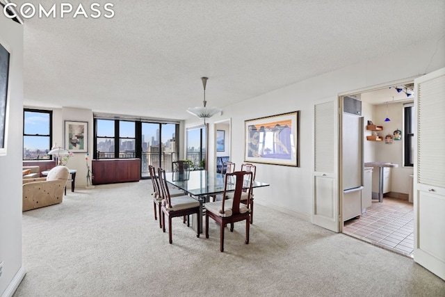 carpeted dining space featuring a chandelier and a textured ceiling