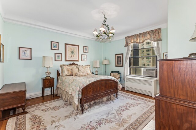 bedroom with baseboards, an inviting chandelier, wood finished floors, and radiator