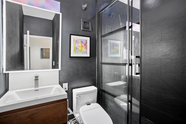 bathroom featuring visible vents, vanity, toilet, and a shower stall